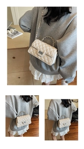 Détails du sac matelassé beige avec bandoulière en chaîne argentée et fermoir pivotant