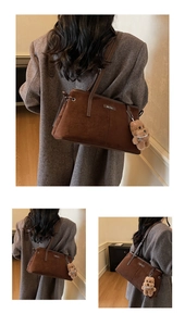 Détail du sac cabas en daim marron foncé avec pendentif ours en peluche et logo en métal