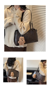 Détail du sac à bandoulière rétro marron foncé avec logo argenté et breloque ours