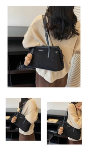 Détail du sac cabas noir mat avec de fines bandoulières en cuir et un charme d'ours