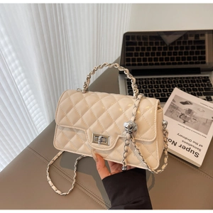 Détail du sac beige en cuir PU matelassé avec fermoir argenté et bandoulière chaîne