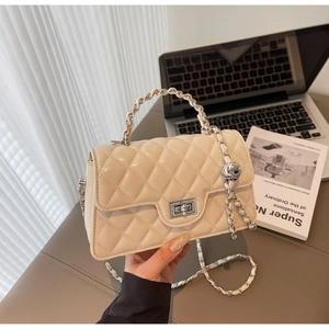Détail du sac beige matelassé avec boucle à bille argentée et serrure métallique