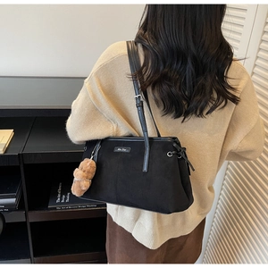 Sac bandoulière en daim noir avec logo métallique doré et charm ours en peluche marron