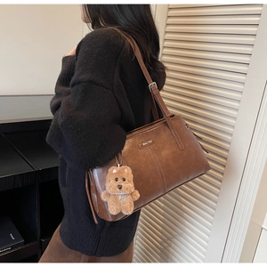 Détail du sac cabas marron vintage en simili cuir mat avec pendentif ours en peluche