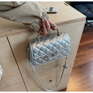 Détail du sac à bandoulière matelassé argenté avec finition métallique et chaîne