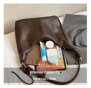 Internal capacity of the dark brown leather tote showing storage for iPad and cosmetics