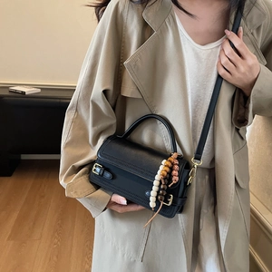 Vintage black matte leather crossbody handbag with beaded charm and gold buckles