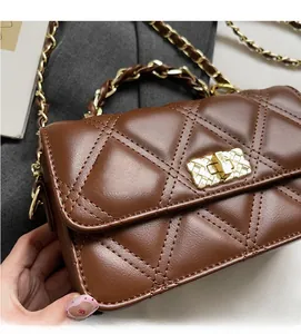 Close-up of brown quilted leather bag featuring a gold chain strap and metal lock
