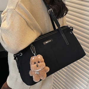Sac fourre-tout chic en toile noire avec bandoulière et pendentif ours sur modèle