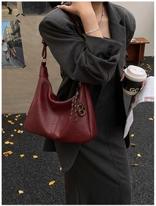 Close-up of deep red leather tote bag with elegant side knot detail and soft texture