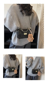 Close-up of black quilted chain bag featuring a gold twist lock and cute bear charm