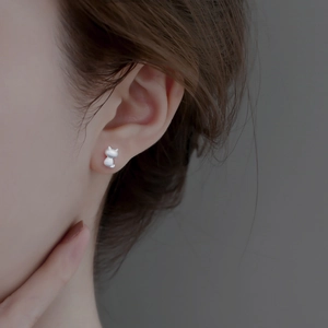 Detailed macro shot of matte S925 silver cat-shaped stud earring worn on the ear