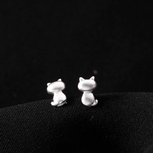 Macro shot of matte S925 silver cat earrings showing detailed texture and cute tail design