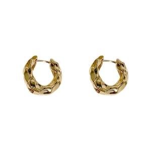 Golden metal hoop earrings with irregular hammered texture on a clean white background