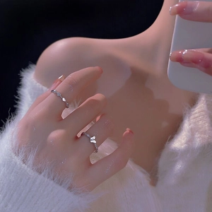 Close-up of S925 silver adjustable rings with butterfly and heart patterns on a hand