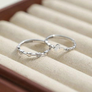 Macro detail of S925 silver butterfly and heart rings with micro-set diamonds