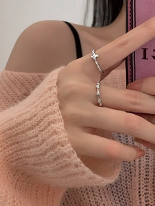 S925 sterling silver butterfly and heart ring set worn on model fingers with knit background