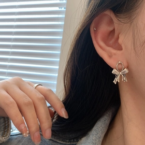 Retro S925 silver bow drop earrings with black crystal accents shown on model's ear