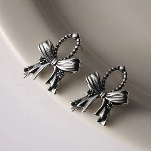 Macro detail of vintage S925 silver bow stud earrings with black zircon setting
