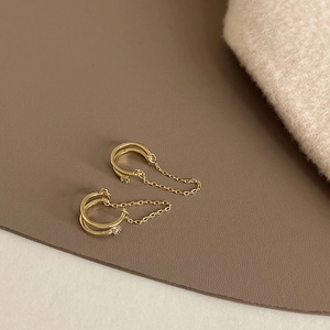 Detailansicht der goldenen Doppel-Ohrklemme mit Kette und Zirkonia-Steinen für Damen