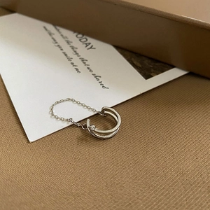 Makroaufnahme einer doppellagigen s925 Silber Ohrmanschette mit Kette auf Stoffhintergrund