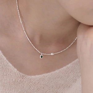 Elegante collana in argento S925 con gemma smeraldo e perla indossata da una modella