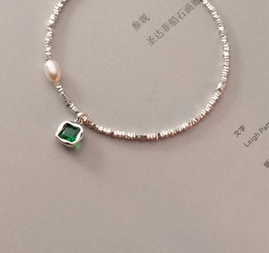 Dettaglio della collana di perline in argento S925 con perla bianca e ciondolo smeraldo