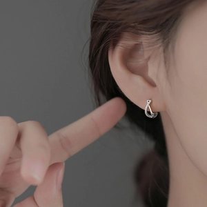 Detail of S925 silver geometric twisted hoop earrings with micro-set shimmering diamonds