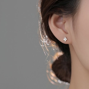 Primer plano de pendientes de estrella de plata S925 con diamantes en una modelo femenina