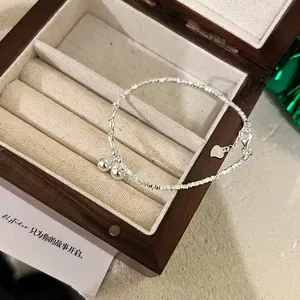 Elegant S925 sterling silver bamboo chain bracelet with bell pendants in a jewelry box