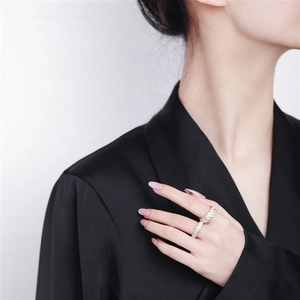 Close-up of gold fan-shaped scale rings with micro-pave crystals on a model hand