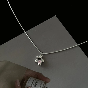 Collier chaîne serpent argentée avec pendentif fleur en zircon rose sur carte grise