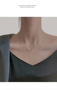 Detail of silver S925 tassel necklace with diamond olive leaf pendant on model