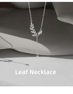 Detail of silver leaf necklace with marquise zircons and elegant tassel pendant