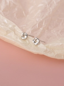 Elegant S925 sterling silver knot stud earrings for women on a pink textured background