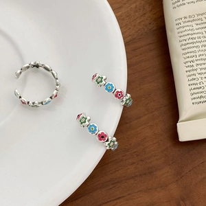 Close-up of three S925 silver open rings featuring colorful enamel floral designs