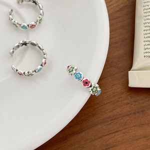 Detail of three S925 silver rings with colorful daisy enamel petals and adjustable band