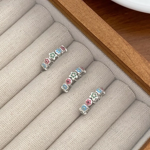 Detail of S925 sterling silver rings with colorful enamel floral patterns in a jewelry box