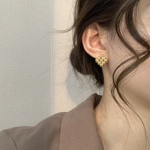 Minimalist gold woven diamond square stud earrings for women shown on a model