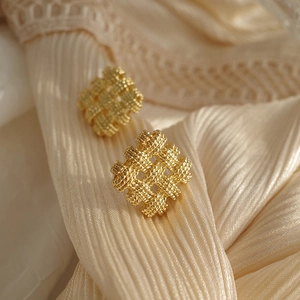 Elegant woven square gold stud earrings on champagne silk background with vintage style