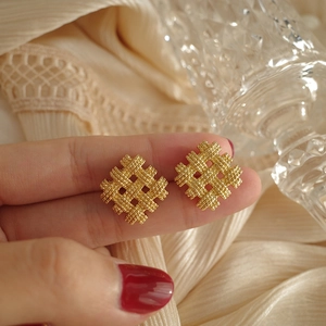 Minimalist gold woven diamond earrings featuring intricate braided texture and vintage style