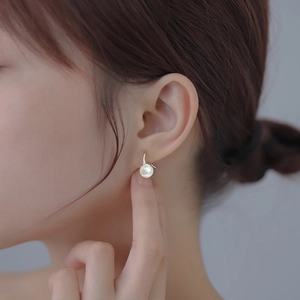 Élégantes boucles d'oreilles pendantes en perles argent S925 portées par un mannequin