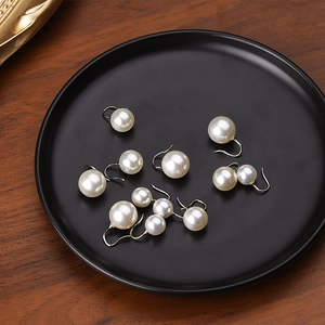 Gros plan de boucles d'oreilles vintage en argent S925 et perles sur un plateau de luxe