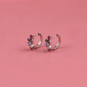Silver hoop earrings with five multicolored round zircons on a pink background