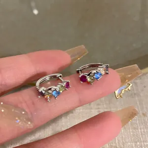 Macro detail of silver mini hoop earrings with multi-colored cubic zirconia stones