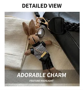 Détail du bijou de sac lapin en tricot marron avec gilet pied-de-poule et chaîne dorée
