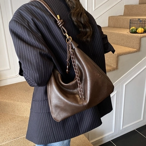 Retro deep brown large hobo bag with knotted strap and gold hardware on a model