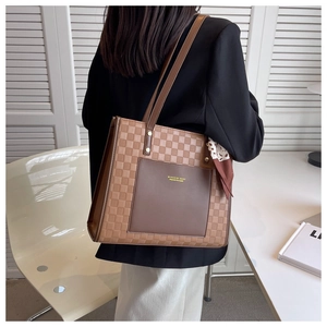 Detail of brown checkerboard tote bag with printed silk scarf on shoulder strap