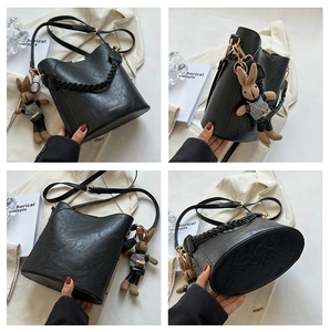 Détails du sac seau noir avec texture litchi et charmant pendentif lapin décoratif