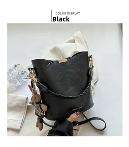 Détail du sac seau noir texturé avec poignée tressée et breloque lapin mignonne